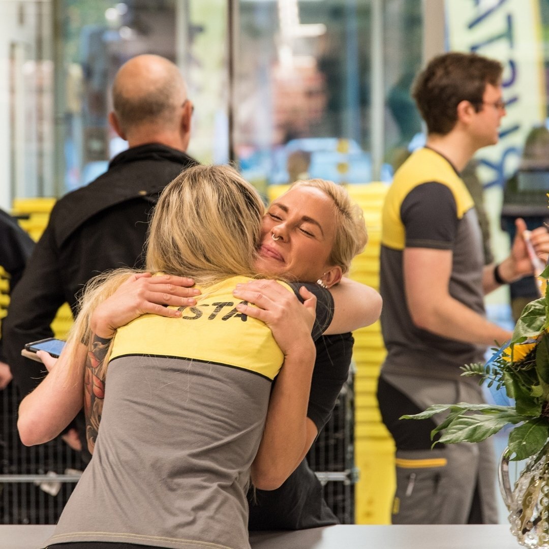 Two colleagues from Rusta hugging each other and smiling